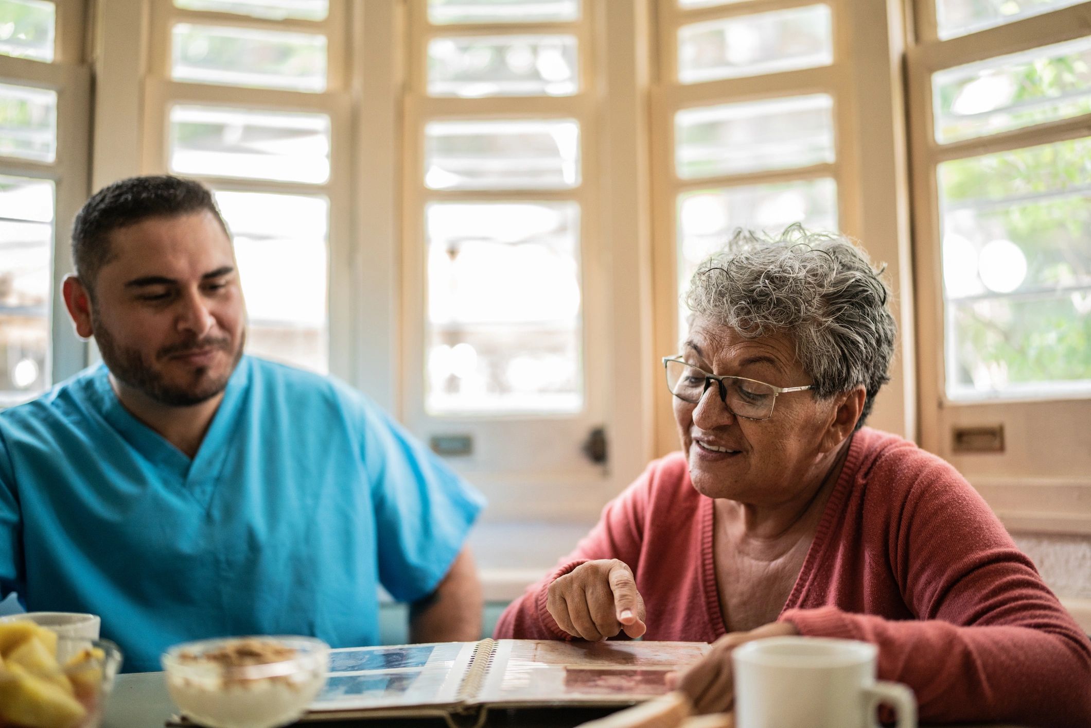 Nurse and senior patient sharing a supportive moment at home