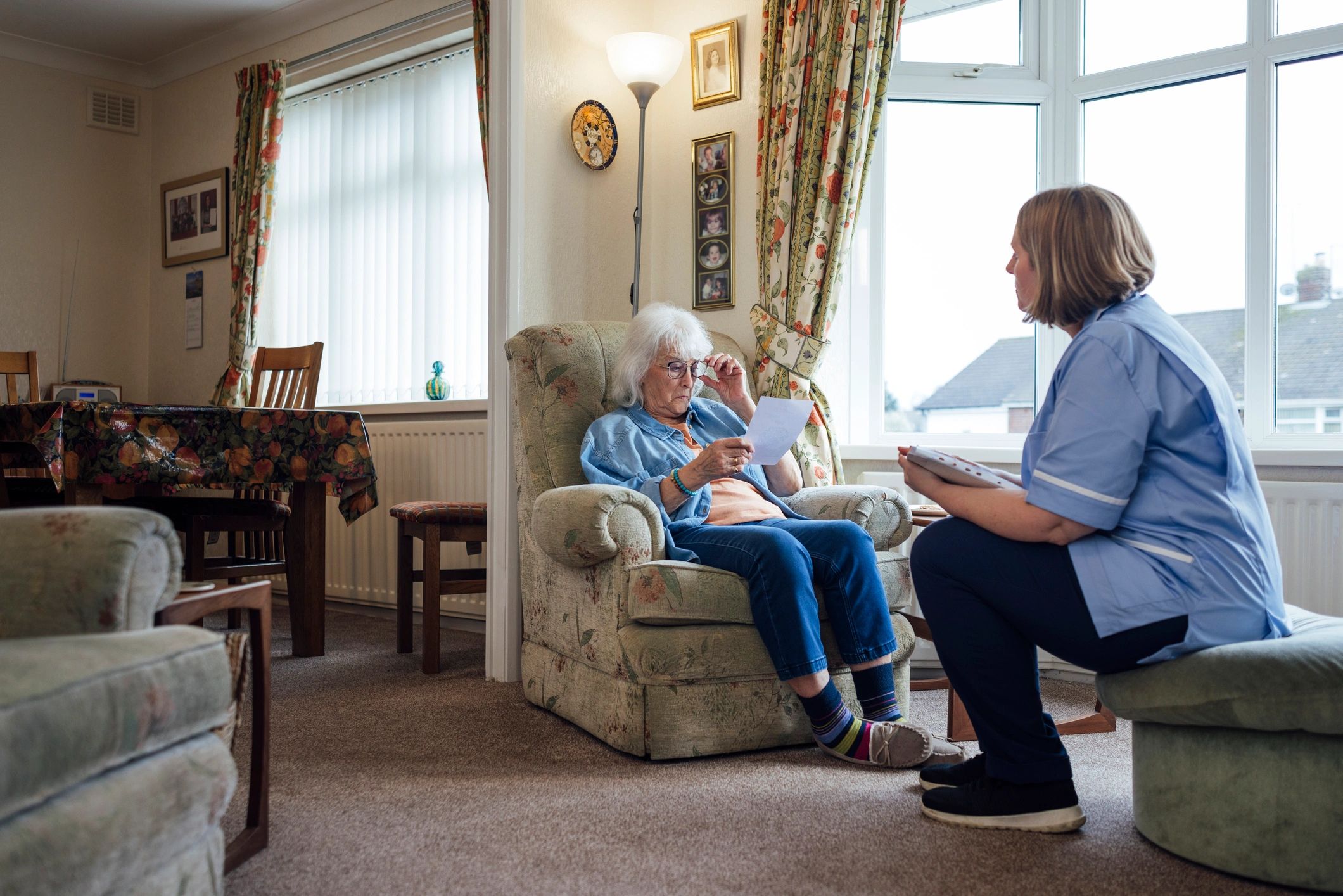 Home health professional speaking with a patient at home