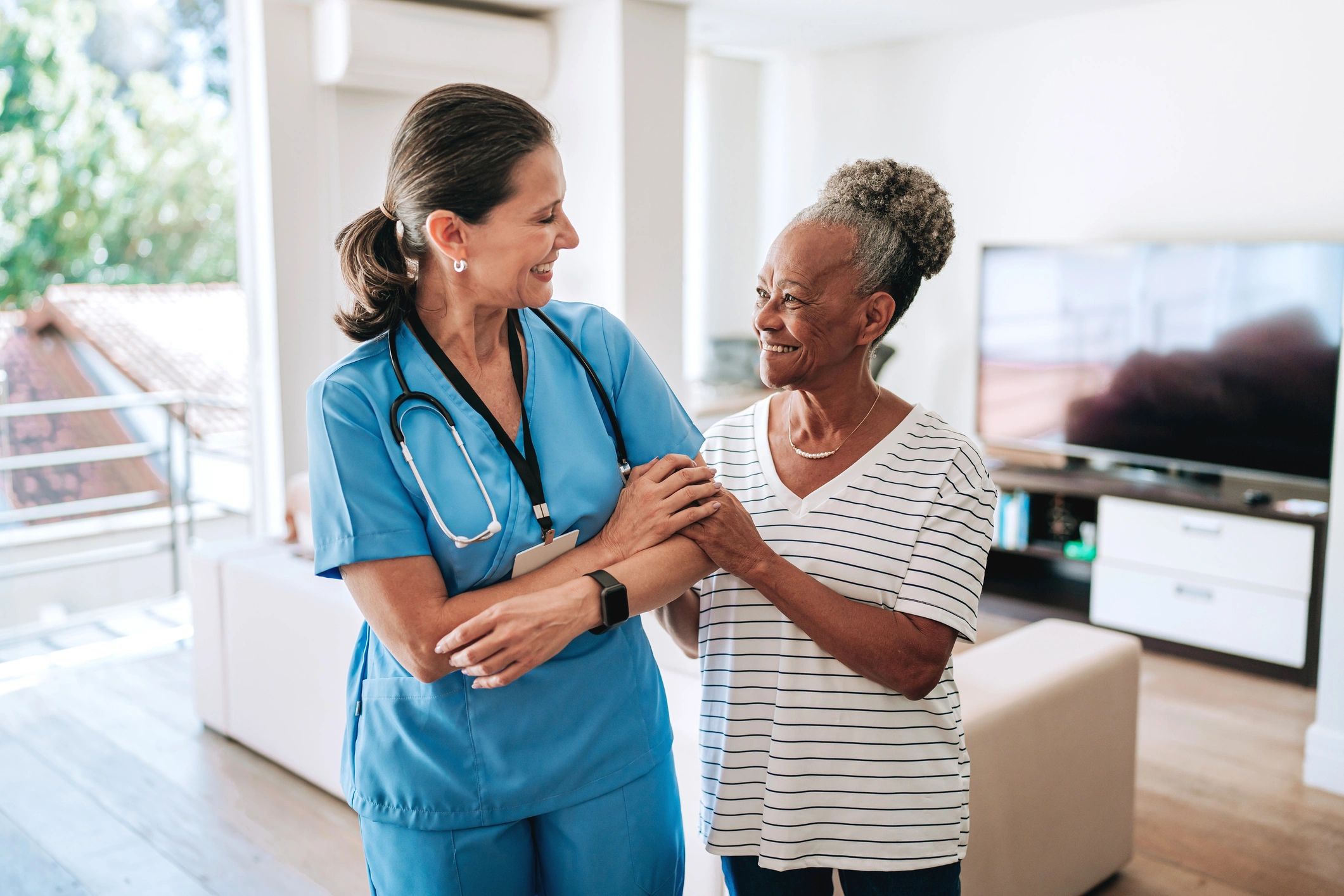 Home care healthcare professional hugging elderly patient