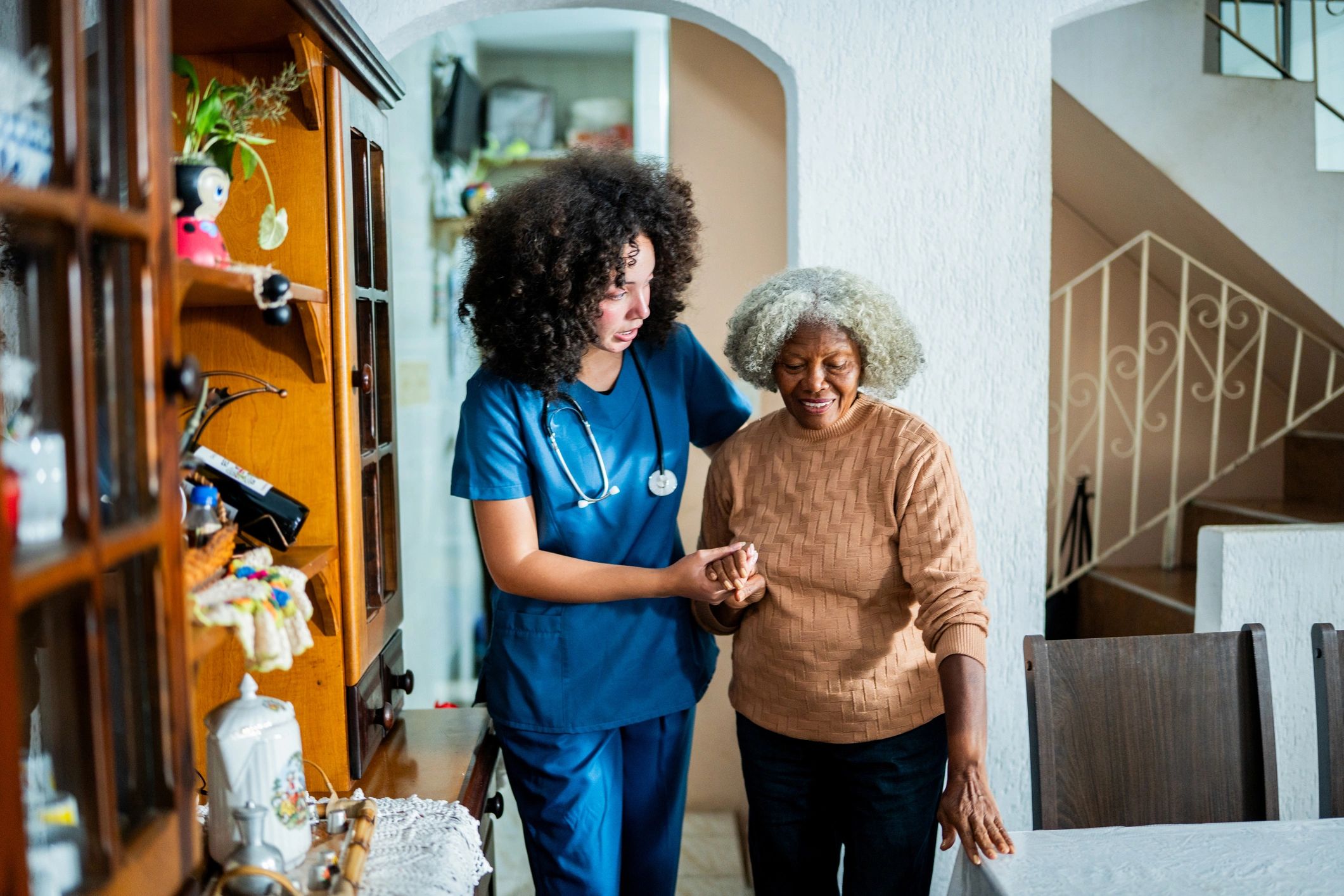 Home caregiver helping a patient walk