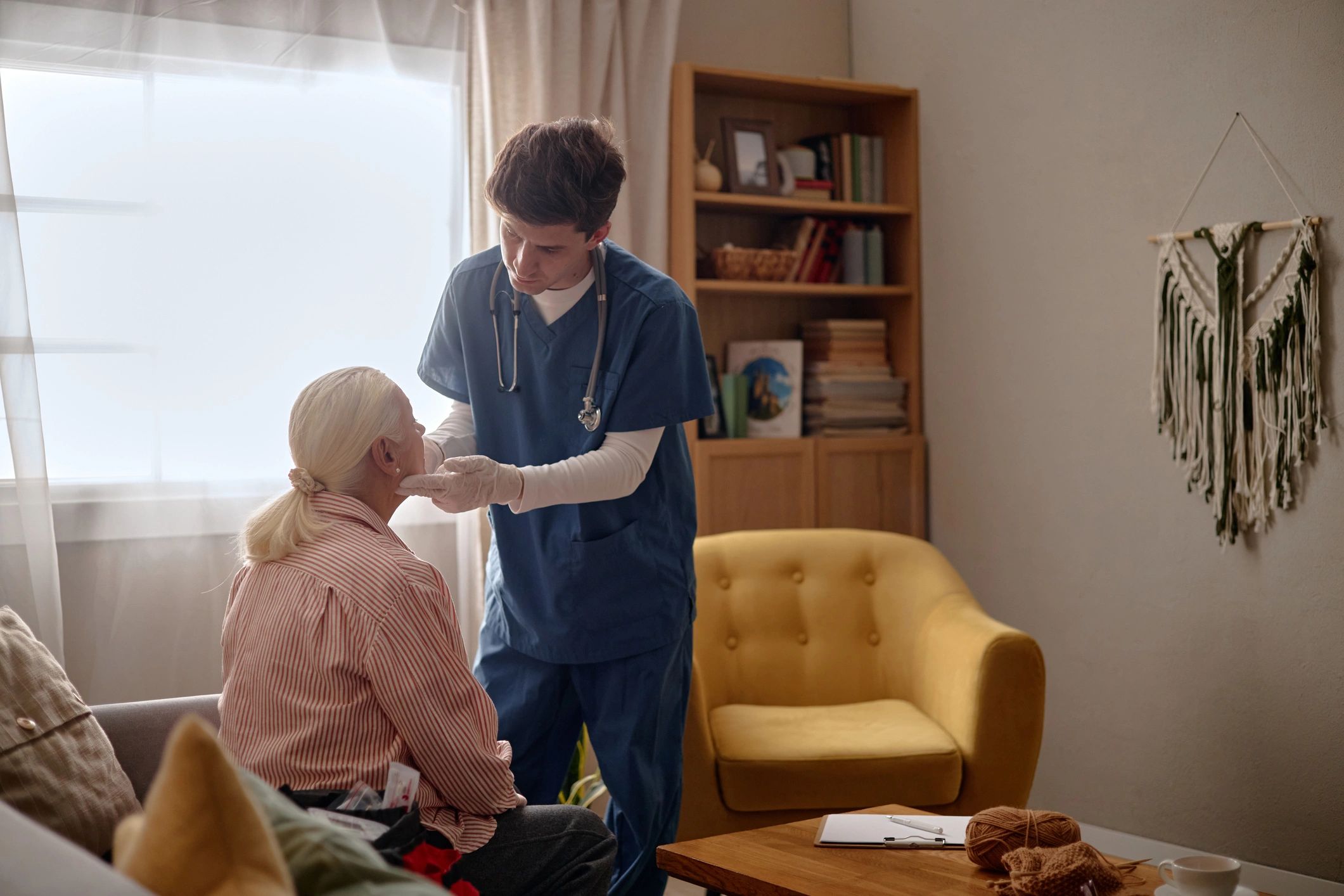 Nurse examining senior woman during home wellness check